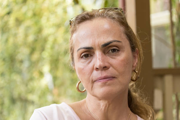 Concerned mature hispanic or middle eastern woman looking at the camera concerned